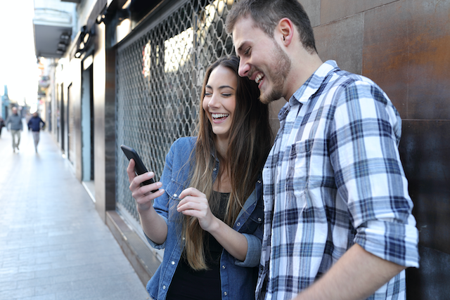 Two teenagers looking at a smartphone