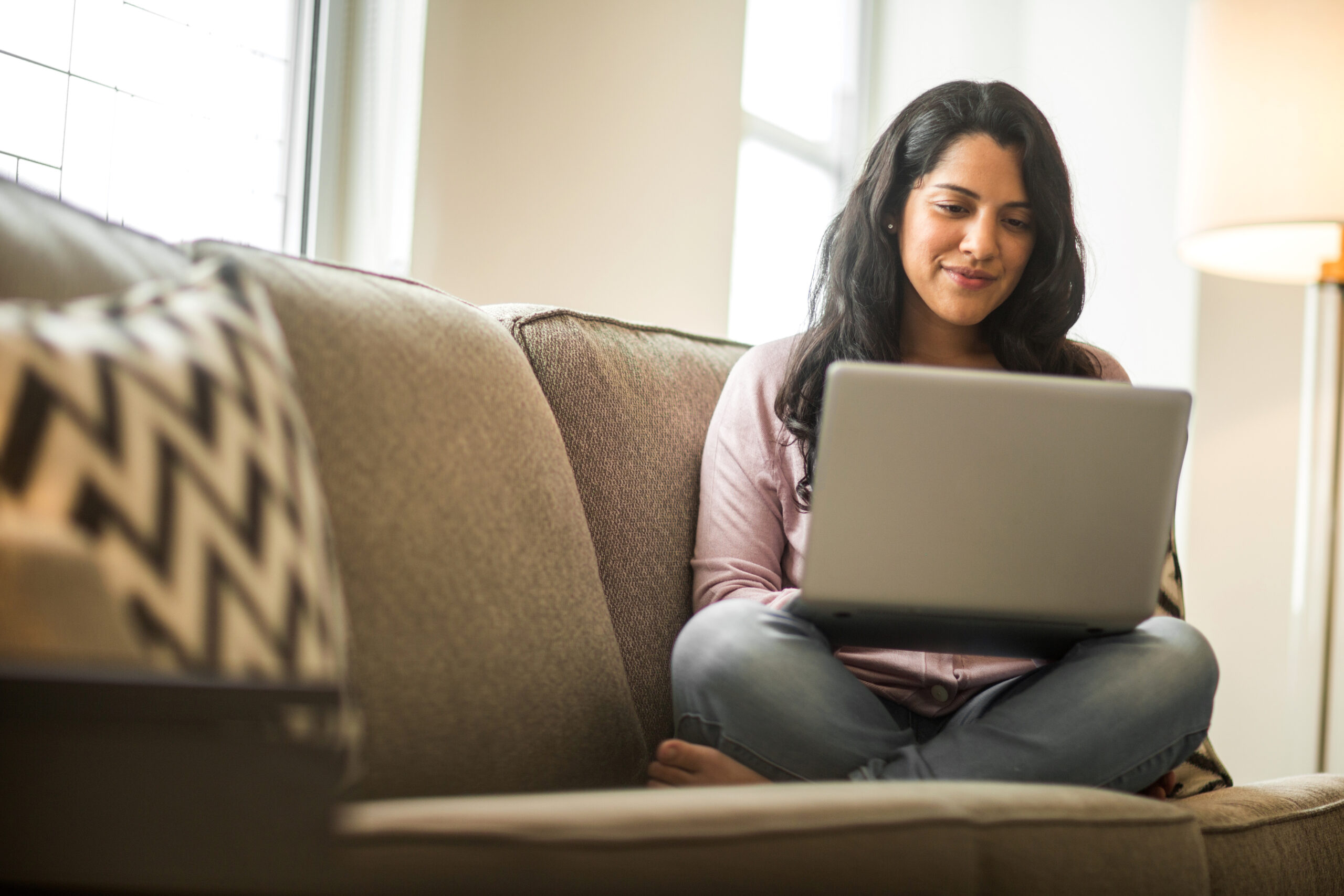 Hispanic woman at home working on a computer.