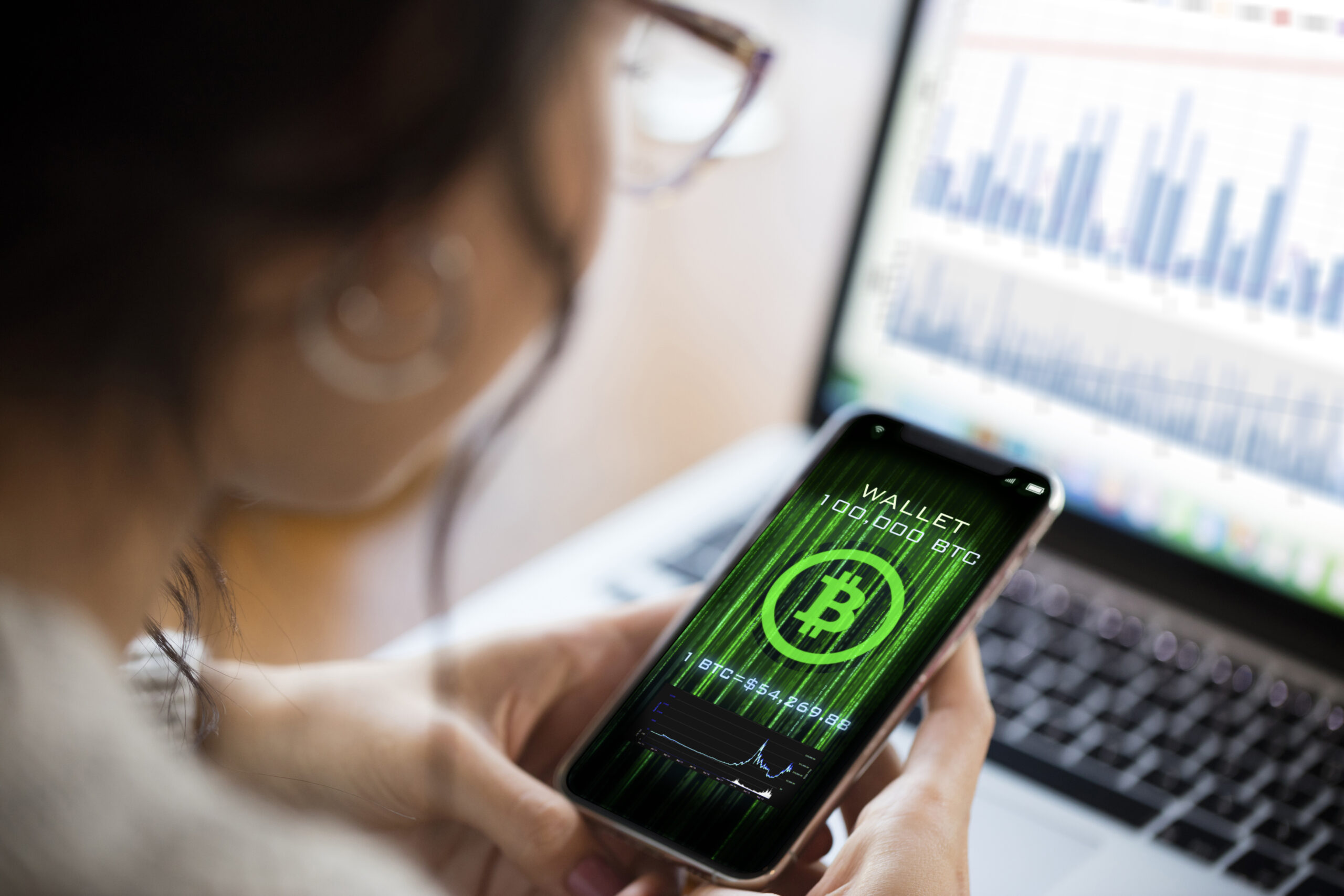 Young woman using cryptocurrency application on smartphone
