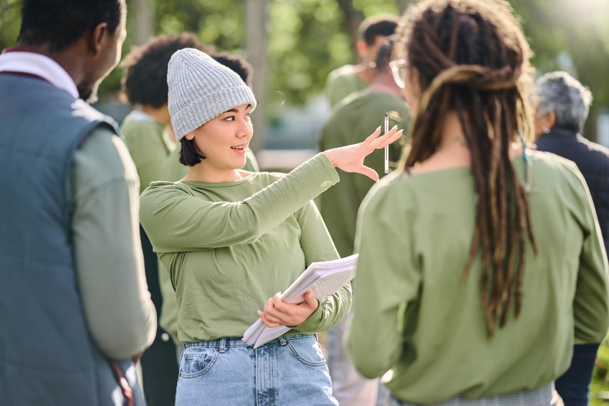 Woman outdoors directing community volunteers.
