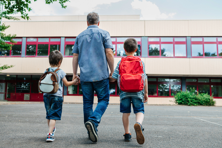 Father walking his two sons into school