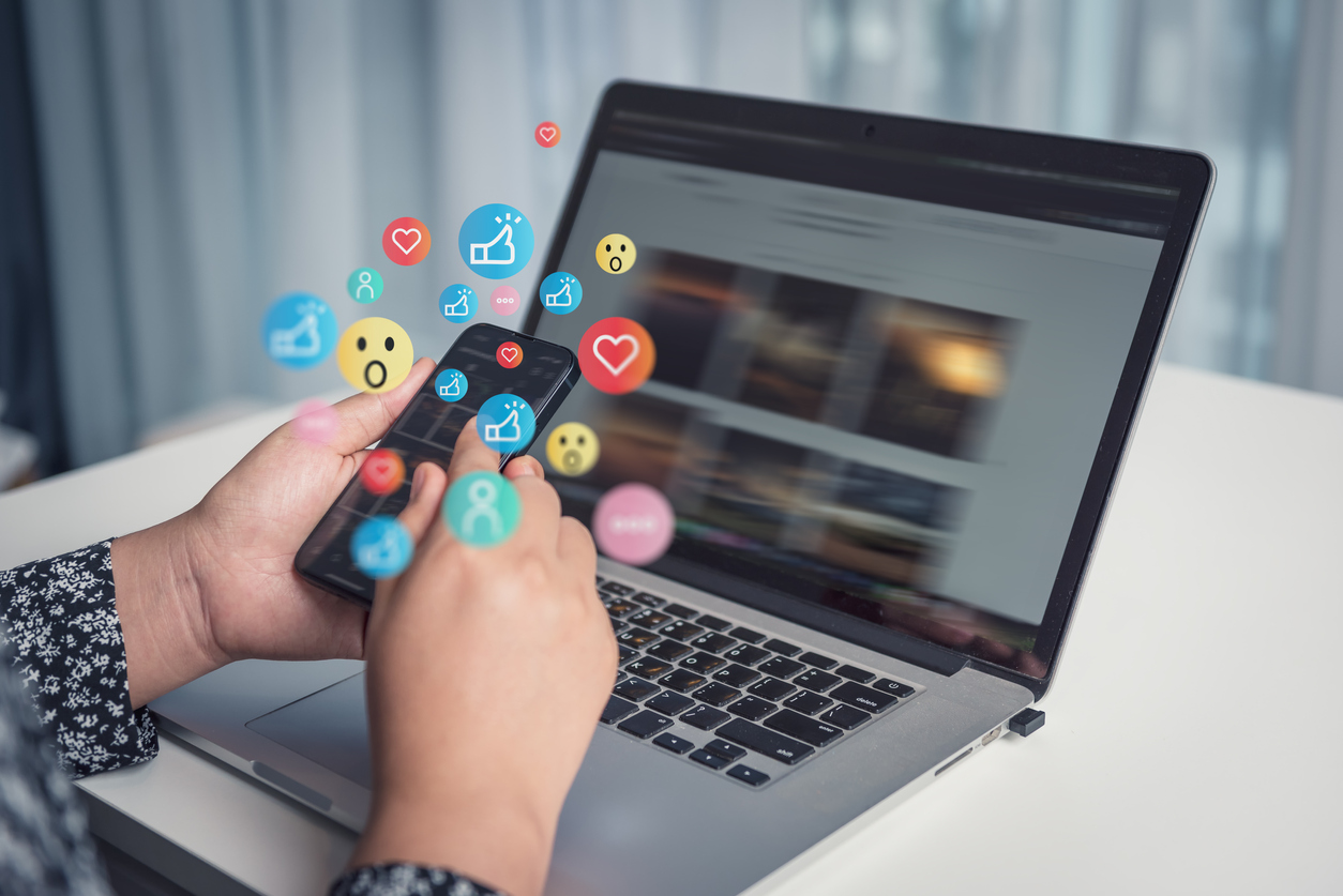 Engagement and emoji reactions coming out of an iphone that is showing a social media feed